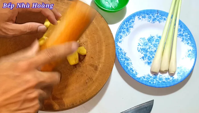 Chuẩn bị gừng và sả: Gọt vỏ gừng, đập dập và thái nhỏ. Đập dập và cắt đôi sả. (94.759)