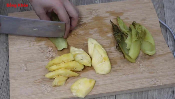 Bóp rửa cải chua cho bớt chua, cắt khúc.