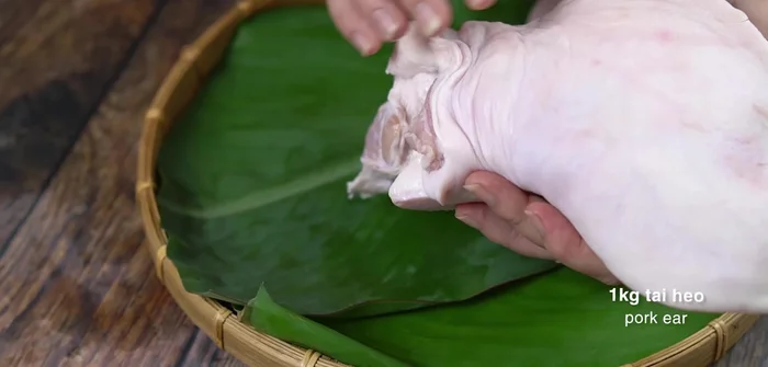 Sơ chế tai heo: Cạo sạch, rửa sạch, cắt bỏ phần tai trong. Dùng muối và chanh chà xát, rửa lại. Cắt đôi.