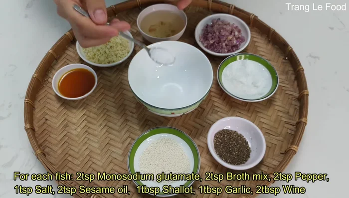 Trộn gia vị ướp cá: bột ngọt, hạt nêm, tiêu, dầu mè, hành tỏi băm, rượu gừng/rượu trắng. Ướp đều gia vị vào cá, để ít nhất 30 phút cho cá ngấm.