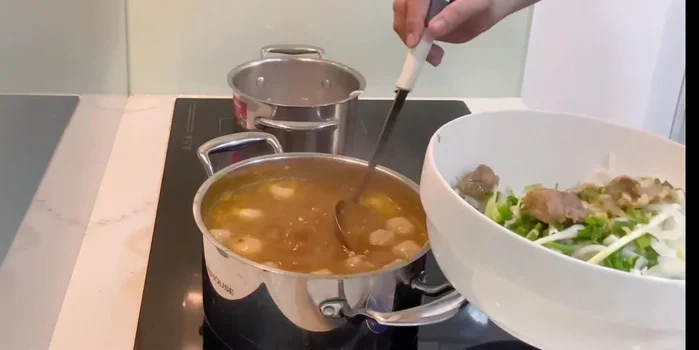 Cho bún vào tô, chan nước dùng lên trên. Thêm bò viên, rau sống, rau thơm, trứng (nếu dùng), chanh, ớt sa tế vào tô.