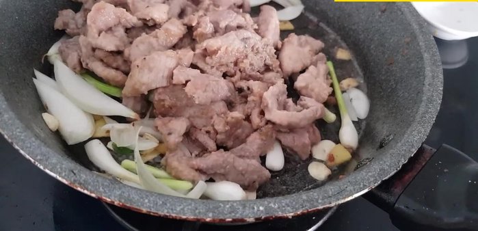 Cho thịt đã xào vào chảo hành tây, trộn đều.