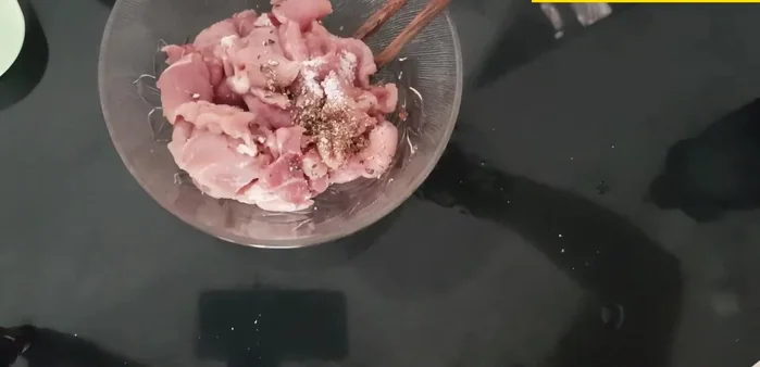 Cho thịt heo vào chảo, thêm muối, hạt tiêu, rau mùi, nước tương.