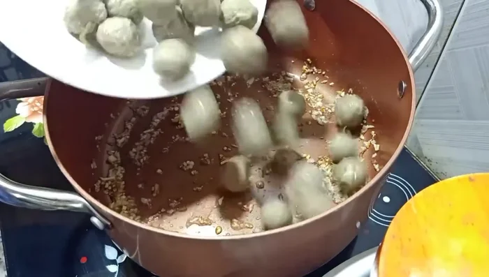 Cho bò viên vào, khuấy đều khoảng 2 phút cho bò viên hơi vàng.