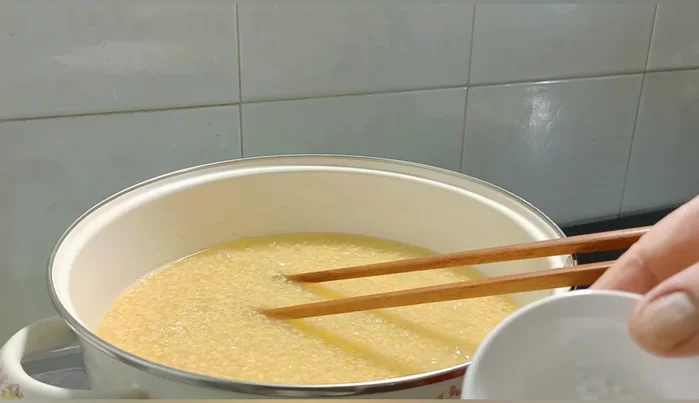 Khi nước đường sôi, hạ lửa nhỏ, cho thêm 1g muối, khuấy đều trong 10 phút.