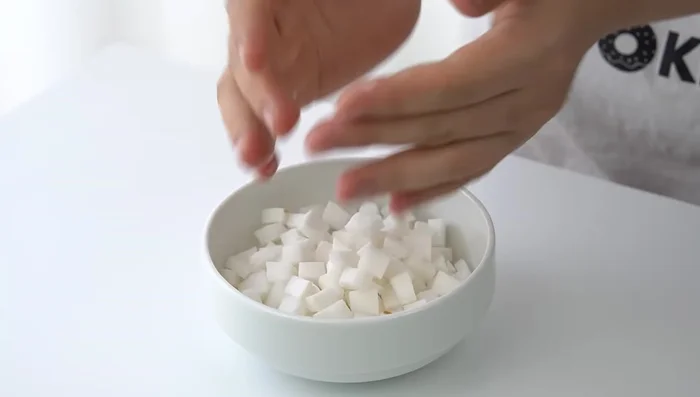 Xử lý dừa non: Gọt vỏ, thái sợi hoặc hình tùy thích, cho vào tủ lạnh.