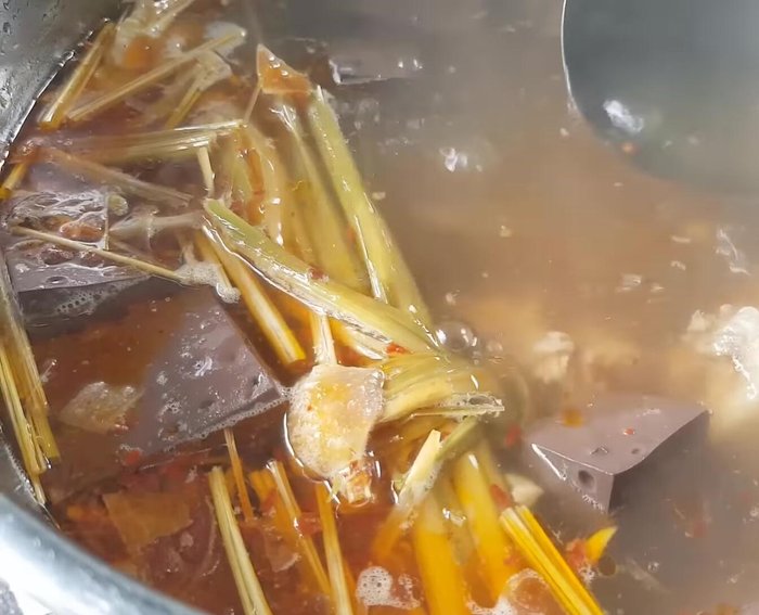 Đun sôi khoảng 2 phút cho gia vị tan đều, sau đó vớt bớt sả, hành, tỏi, ớt.