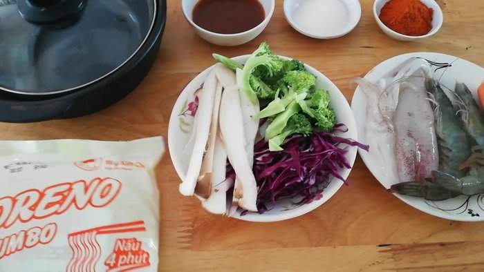 Chuẩn bị nguyên liệu: rau súp lơ, cải tím, nấm, đùi gà, tôm, mực, xúc xích, bột ớt Hàn Quốc, đường, nước dùng lẩu.