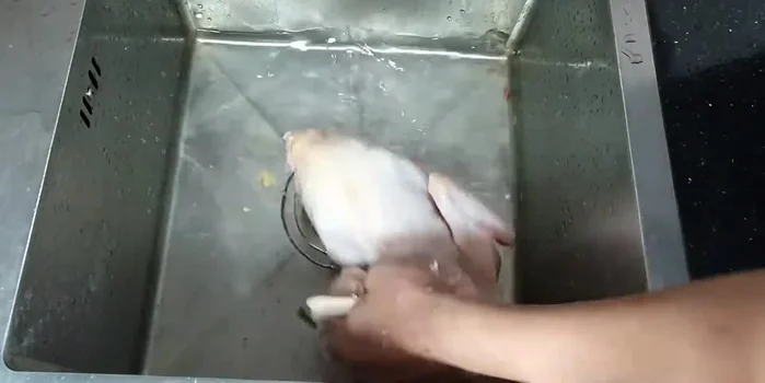 Rửa sạch gà, sát chanh và muối để khử mùi hôi.