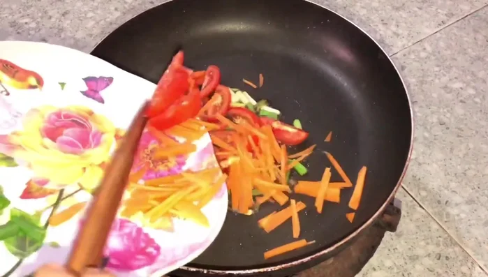 Cho cà chua, cà rốt và hành lá còn lại vào xào.