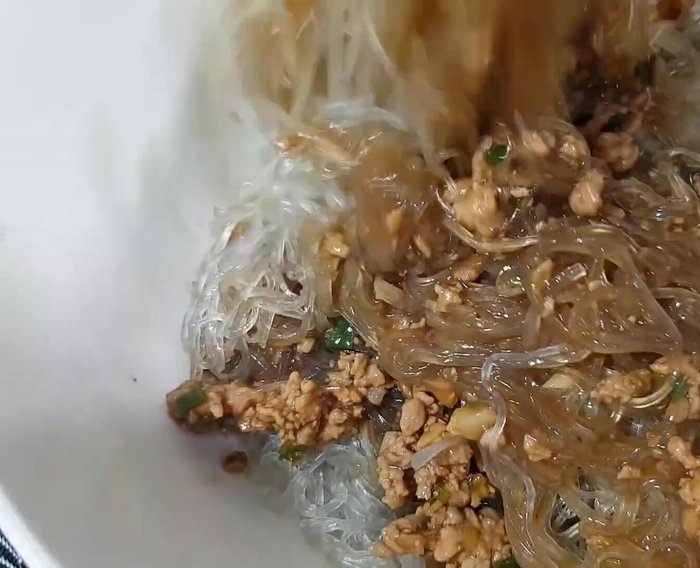 Trộn đều miến với nước sốt thịt băm, giá đỗ, dưa leo.
