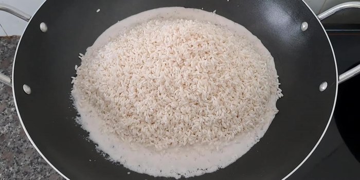 Cho nếp vào chảo, đảo đều cho đến khi nước cốt dừa rút gần hết (khoảng 6-7 phút).