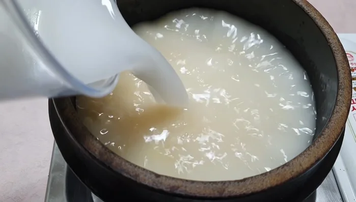Đổ 700ml nước vo gạo vào nồi.