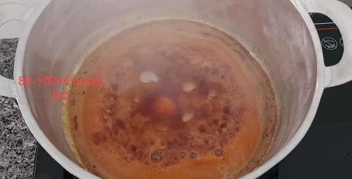Từ từ cho nước vào hỗn hợp caramen, khuấy đều cho tan.