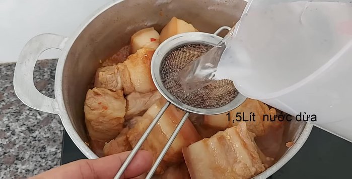 Cho nước dừa vào, tiếp tục đun.