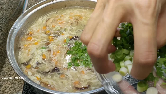 Cho hành lá, ngò rí, tiêu vào. Đun sôi nhẹ rồi tắt bếp.
