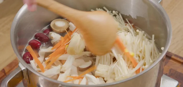 Cho nấm vào, đun sôi lại. Nêm nếm gia vị (bột canh, bột nêm, bột ngọt, nước mắm).