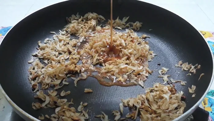 Đổ nước sốt vào chảo ruốc, đảo đều.