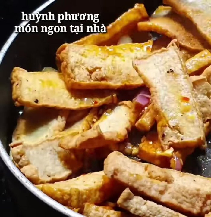 Cho đậu hũ vào, đảo đều cho sốt bám đều lên đậu hũ. Đảo trên lửa nhỏ riu cho đậu hũ hơi khô lại.
