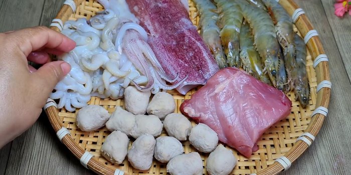 Sơ chế nguyên liệu: Mực làm sạch, lột da, cắt khoanh. Tôm rửa sạch. Thịt nạc thăn thái mỏng. Bắp cải tím, cải thảo cắt miếng vừa ăn. Xúc xích cắt khúc.