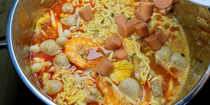 Gần cuối cùng, cho bắp cải tím và xúc xích vào, tắt bếp.