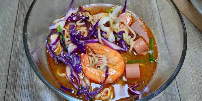 Múc mì cay ra tô và thưởng thức khi còn nóng.