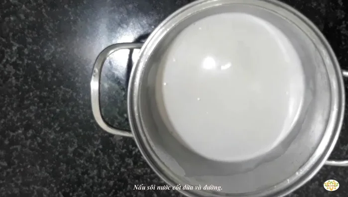 Cho nước cốt dừa, đường vào nồi xôi. Đun sôi.