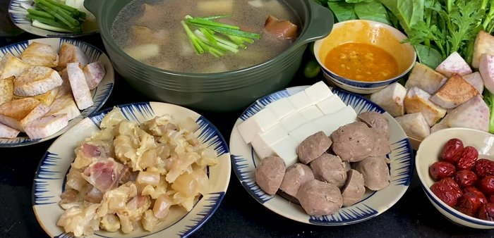 Cho nước dùng vào nồi lẩu, thêm gốc hành lá, hành tây, táo tàu.