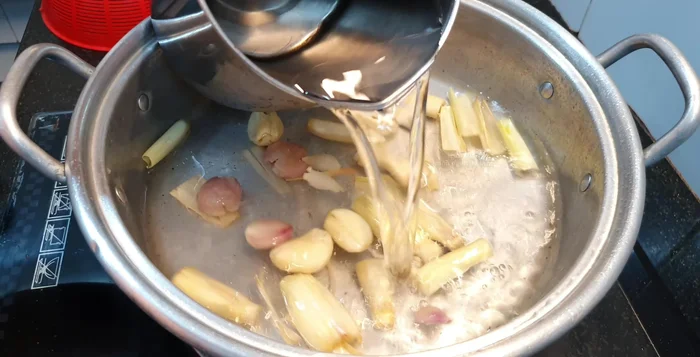 Cho 1 lít nước lọc vào, thêm phần lá sả đã đập dập.