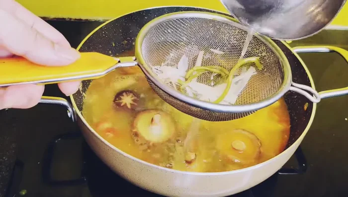 Thêm nước dùng: Cho nước dùng ninh xương cá đã lọc qua rây vào nồi cà chua và nấm đang xào.