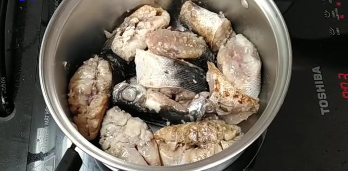 Xếp cá đã chiên vào nồi.