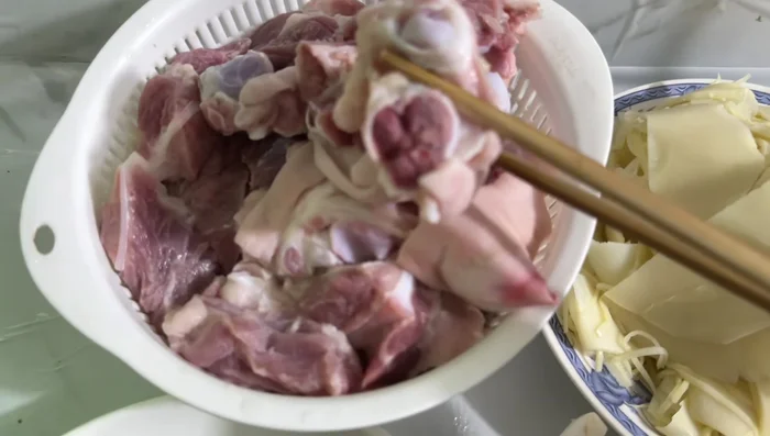 Chặt giò heo thành miếng vừa ăn. Ngâm giò heo với nước muối và giấm khoảng 10 phút, rồi rửa sạch, để ráo.