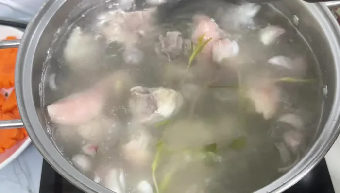 Sau 45 phút hầm giò heo, cho nấm rơm vào hầm cùng 15 phút.