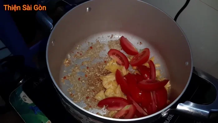 Thêm cá, cà chua và các loại rau củ khác vào nồi lẩu.