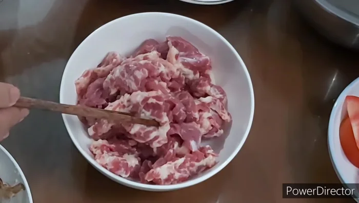 Ướp thịt bò: Thái thịt bò mỏng, ướp với gừng, tỏi băm, hạt nêm, bột ngọt, đường và dầu ăn trong 30 phút.