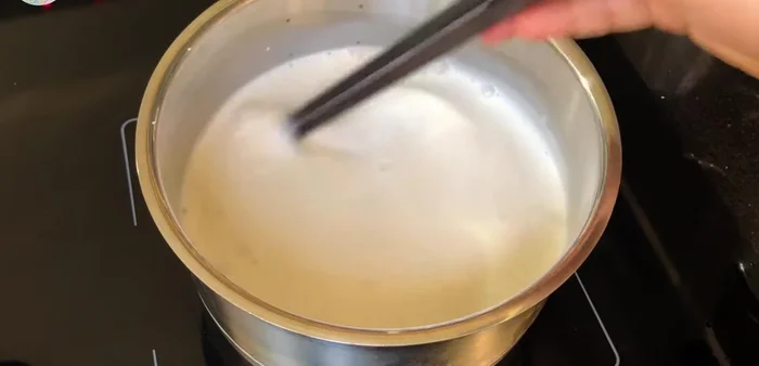 Xôi chín, đổ ra chảo, cho nước cốt dừa và đường đã đun sôi vào, đảo đều cho nước cốt dừa thấm vào xôi. Đảo liên tục trên lửa nhỏ cho đến khi nước cốt dừa rút hết vào xôi, xôi khô và dẻo.
