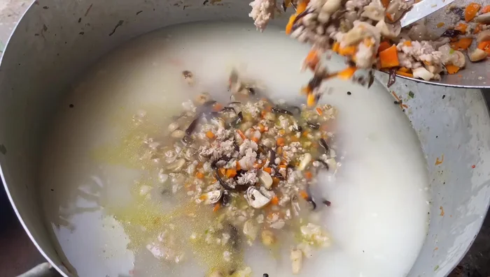 Cho cá mú đã xào vào nồi cháo, khuấy đều.