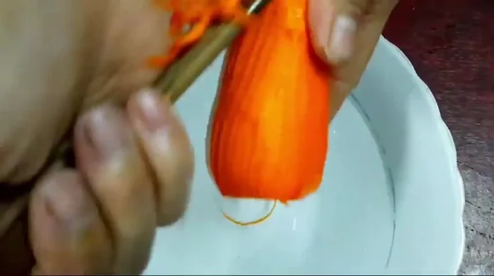 Bào cà rốt thành sợi, nếu muốn chua thì ngâm với giấm. Cho một ít muối vào cà rốt để giảm mùi hăng.