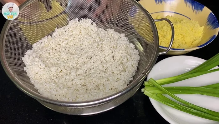 Nếp đã ngâm vớt ra, để ráo. Trộn một nửa lượng đậu xanh xay nhuyễn với nếp, thêm 1 muỗng canh dầu ăn, trộn đều.
