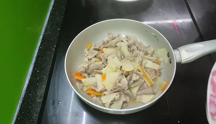 Tắt bếp, cho rau thơm (hành lá, mùi tàu) vào.