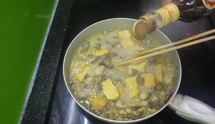 Gần tắt bếp, nêm nếm lại gia vị, cho thêm ớt, lá lốt, tía tô.
