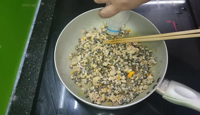 Thêm cơm mẻ, muối, hạt nêm, bột ngọt vào xào chung.