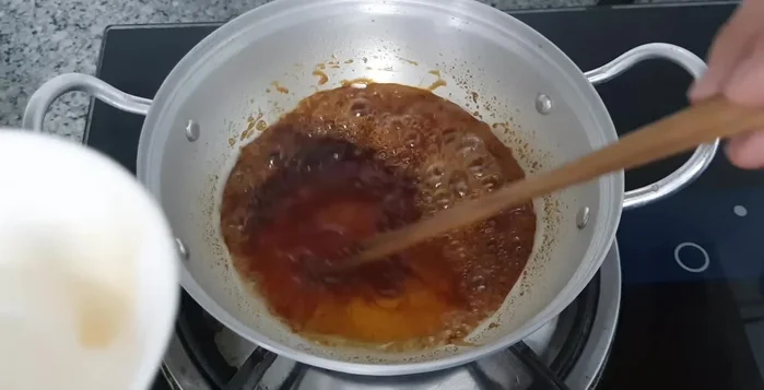 Thêm nước mắm, tương ớt vào hỗn hợp đường đã thắng.