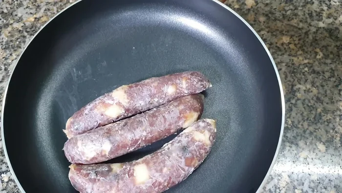 Cho lạp xưởng vào chảo. (39.27)