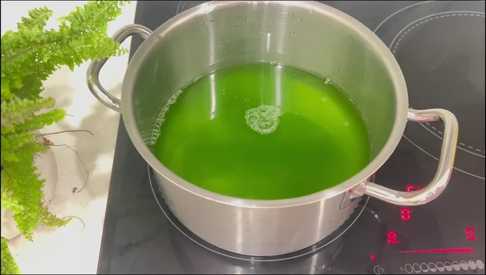 Đun sôi nước cốt lá dứa, sau đó cho hỗn hợp đường và bột rau câu vào, khuấy đều đến khi sôi.