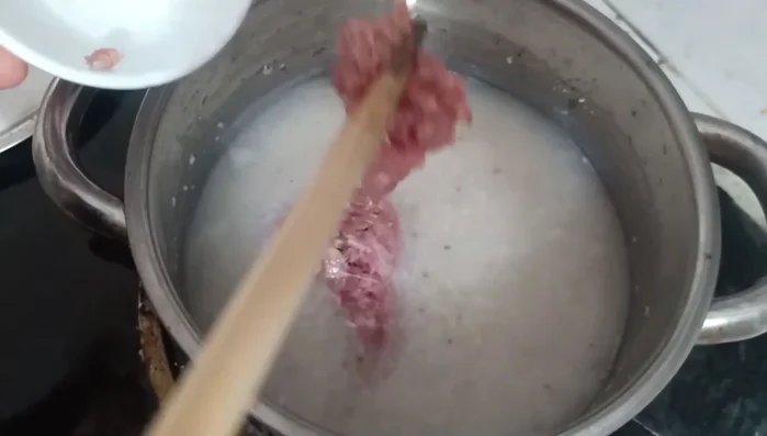 Thêm thịt bò băm nhuyễn vào, khuấy đều để tránh vón cục. Nấu chín thịt bò.