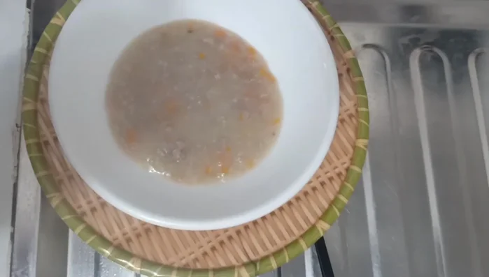 Múc cháo ra bát cho bé ăn.
