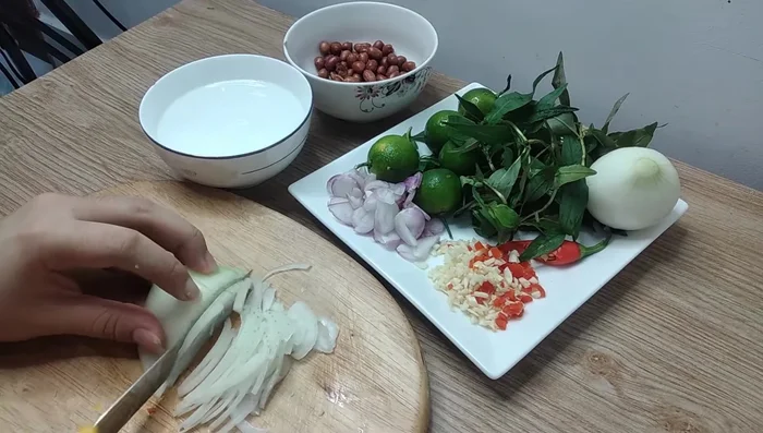 Xắt hành tây mỏng, ngâm nước lạnh để giảm bớt độ hăng.