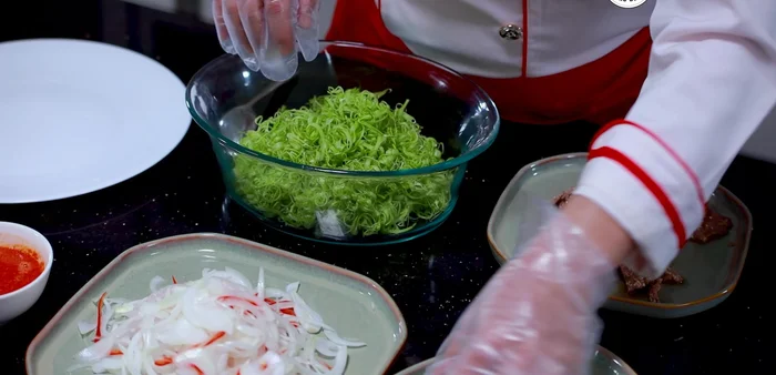 Trộn gỏi: Cho rau muống, hành tây, nước sốt gỏi vào tô lớn, trộn đều. Bóp nhẹ cho rau ráo nước.