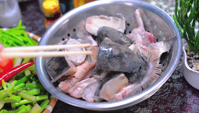 Cạo sạch đầu cá bớp bằng nước muối. (28.489)
